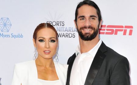 Becky Lynch in a white coat poses with Seth Rollins at ESPN Award show.